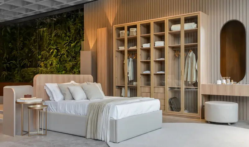 Suíte com closet de portas de vidro e cabeceira estofada